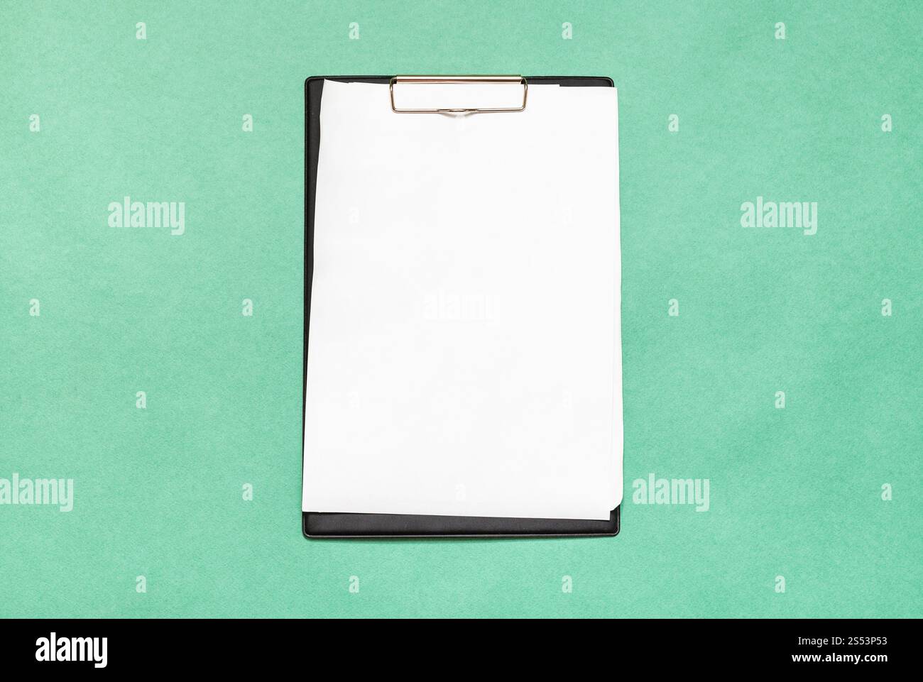 Vue de dessus du presse-papiers avec des feuilles de papier blanc sur fond vert Banque D'Images