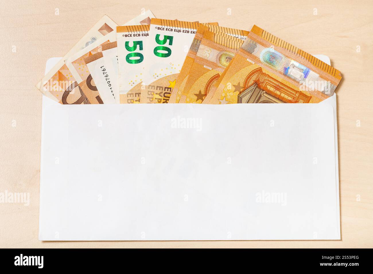 Fan depuis plusieurs Cinquante billets d'euros à ouvrir le courrier enveloppe sur table en bois Banque D'Images