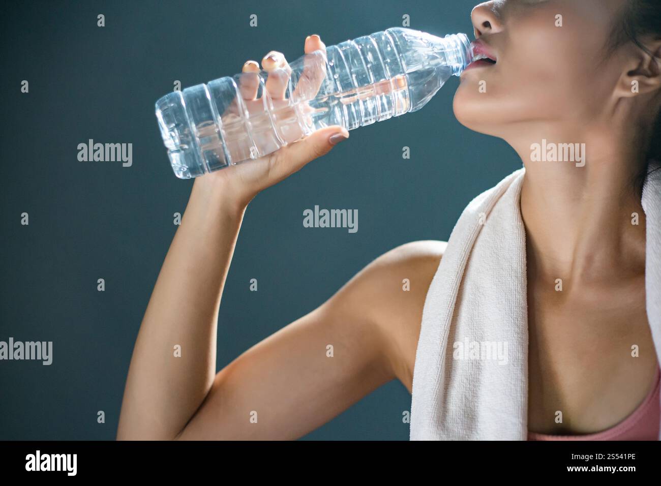 Après l'exercice, les femmes boivent de l'eau à partir de bouteilles et de mouchoirs dans la salle de gym. Banque D'Images