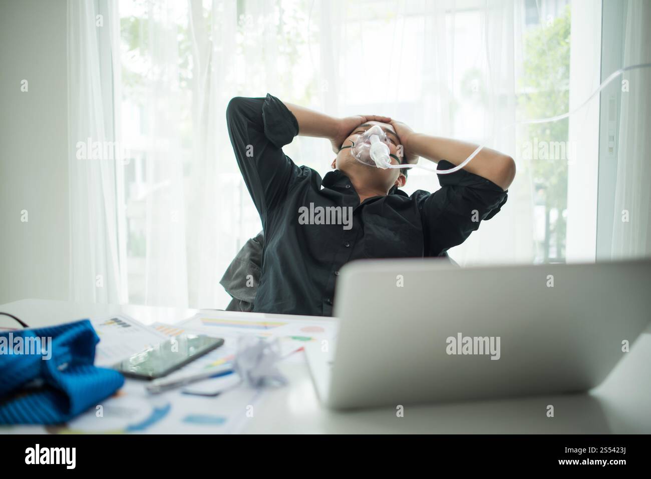 Homme d'affaires avec costume travaillant avec masque à oxygène au bureau. L'homme malade travaille seul dans le bureau Banque D'Images Homme d'affaires avec costume travaillant avec masque à oxygène au bureau. L'homme malade travaille seul dans le bureau Banque D'Images