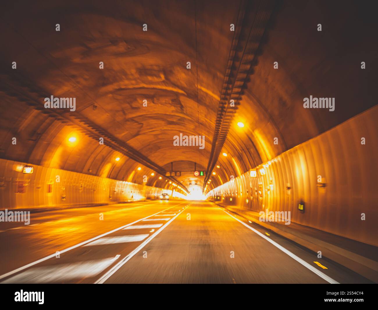 Photo floue tonique de voitures roulant vite dans un long tunnel sous la montagne. Image floue tonique de voitures roulant vite dans un long tunnel sous la montagne Banque D'Images