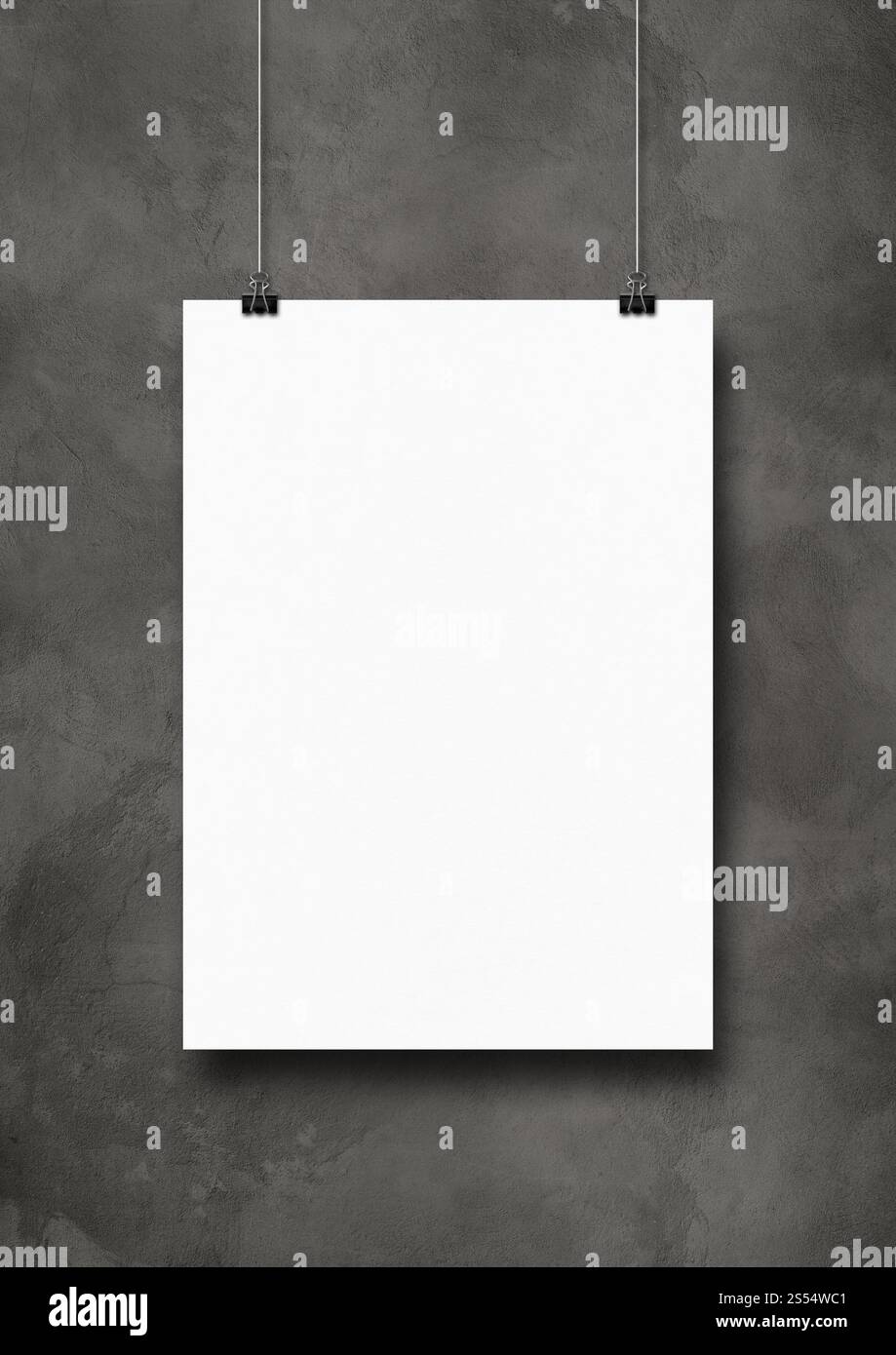 Affiche blanche accrochée sur un mur de béton sombre avec des clips. Modèle de maquette vierge. Affiche blanche accrochée sur un mur de béton sombre avec des clips Banque D'Images