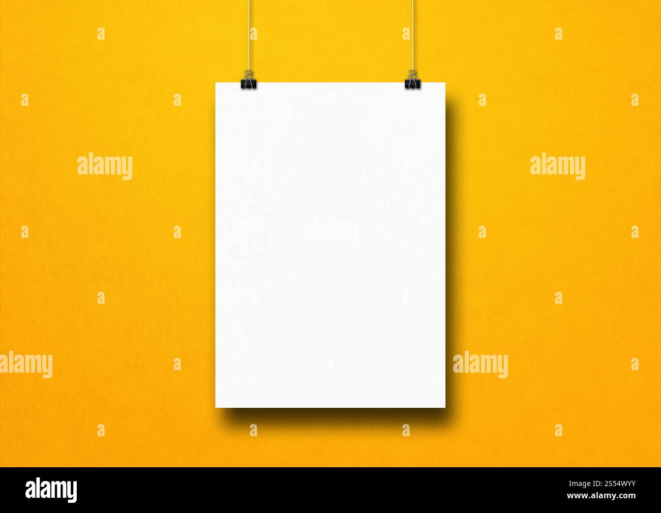 Affiche blanche accrochée sur un mur jaune avec des clips. Modèle de maquette vierge. Affiche blanche accrochée sur un mur jaune avec des clips Banque D'Images