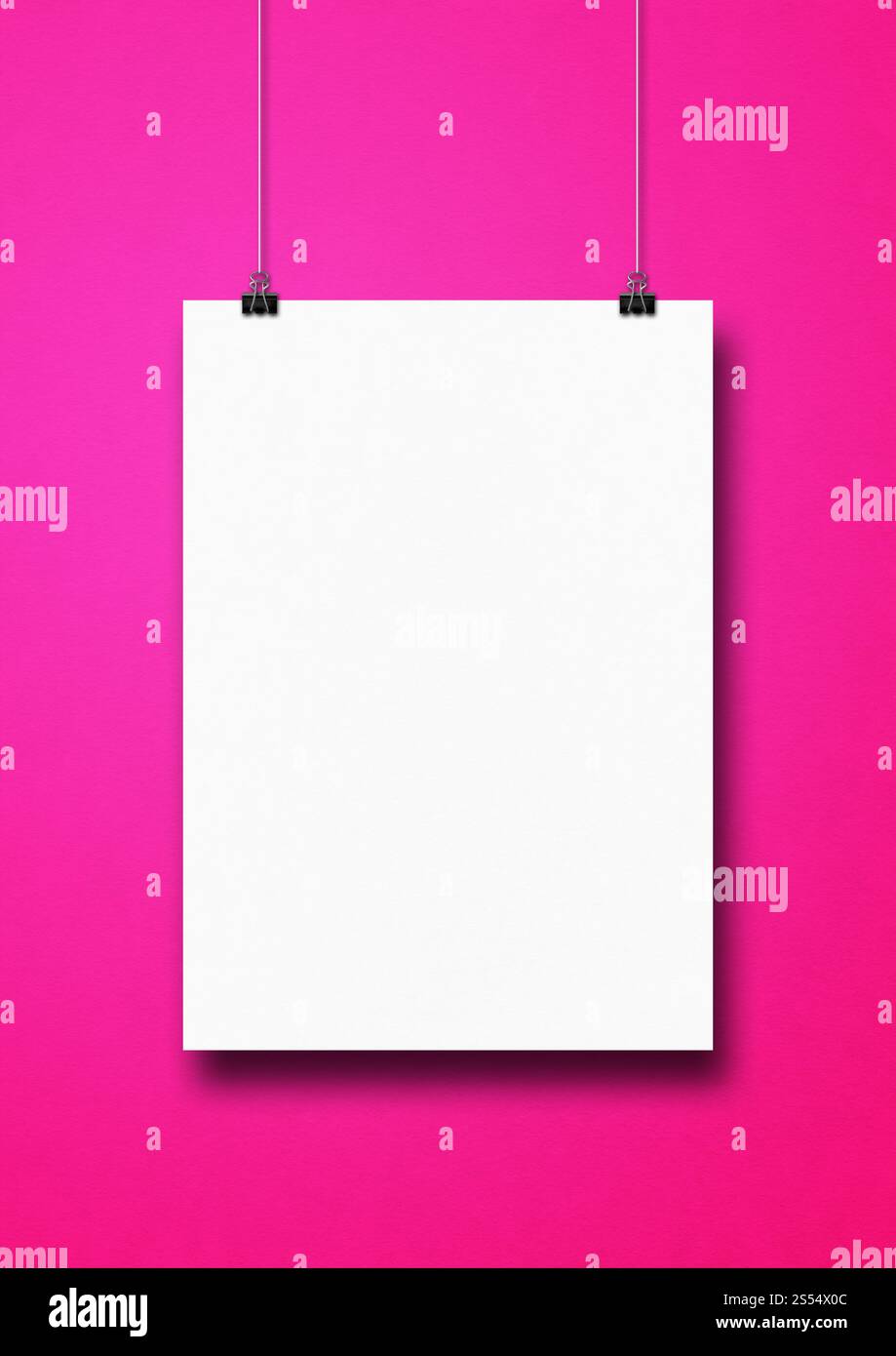 Affiche blanche accrochée sur un mur rose avec des clips. Modèle de maquette vierge. Affiche blanche accrochée sur un mur rose avec des clips Banque D'Images