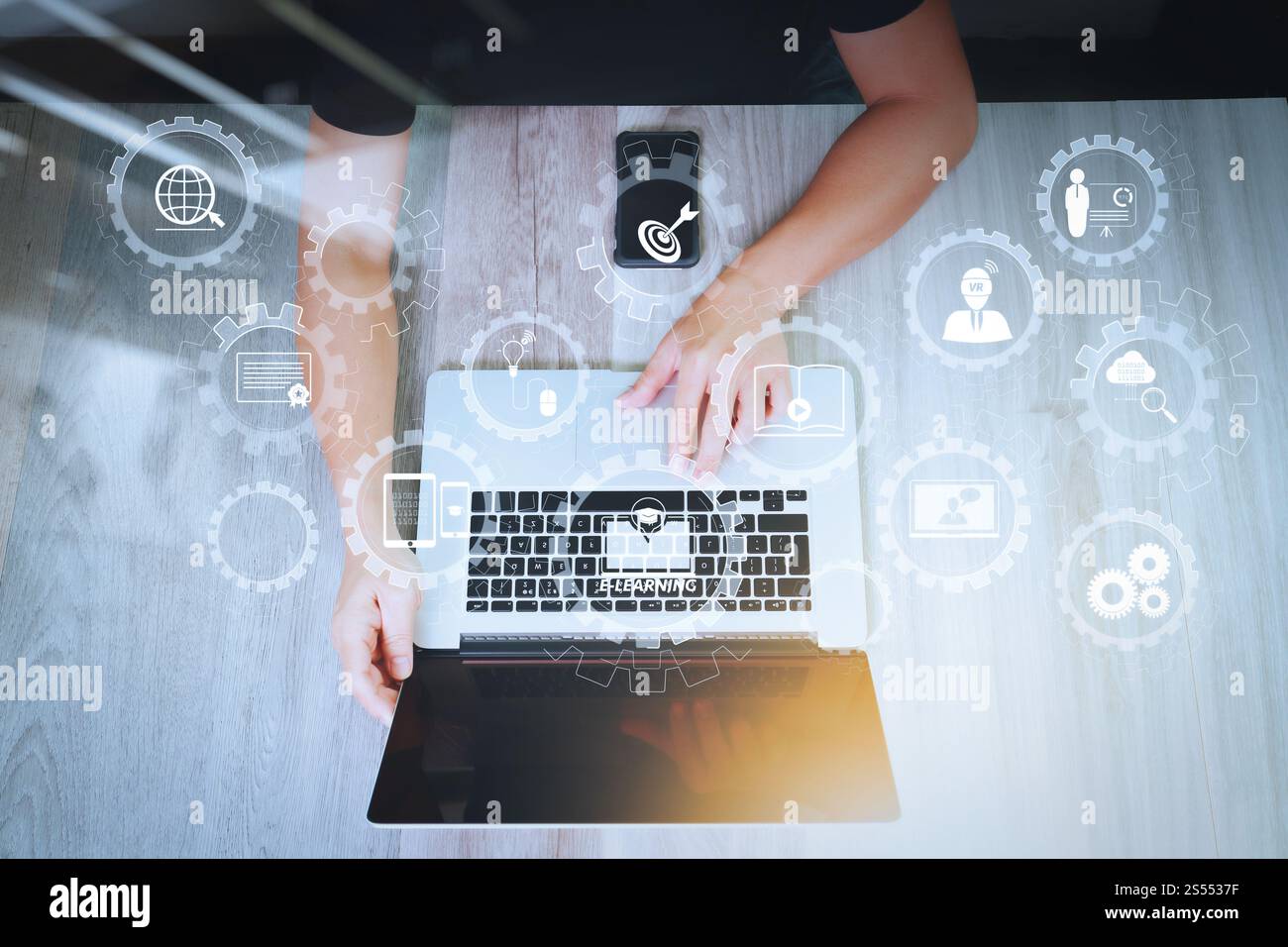 E-learning avec engrenages connectés diagramme connecté tableau de bord virtuel.vue de dessus de la main de concepteur travaillant avec un ordinateur portable et un téléphone intelligent sur Banque D'Images
