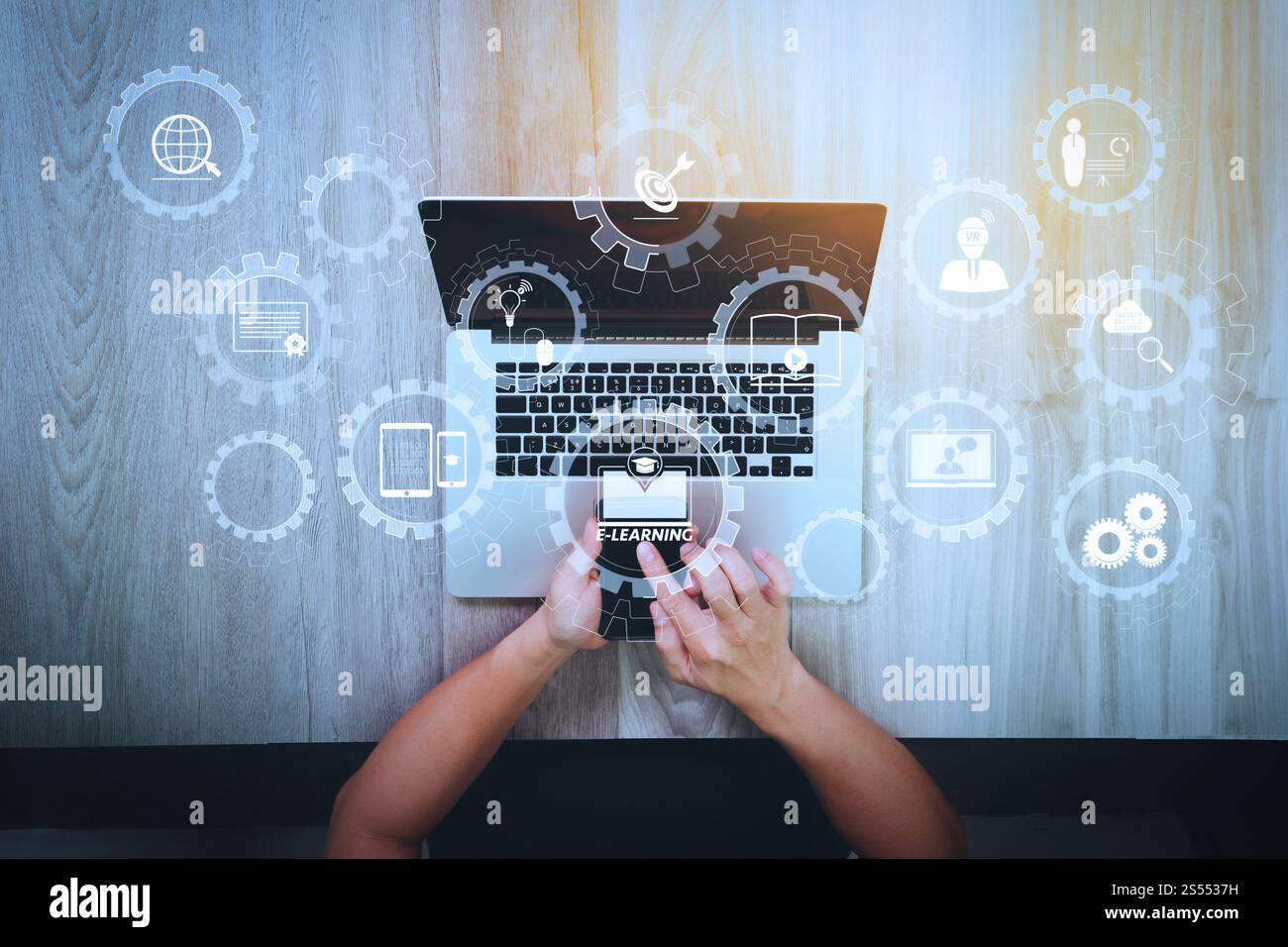 E-learning avec engrenages connectés diagramme connecté tableau de bord virtuel.vue de dessus de la main de concepteur travaillant avec un smartphone et un ordinateur portable sur Banque D'Images