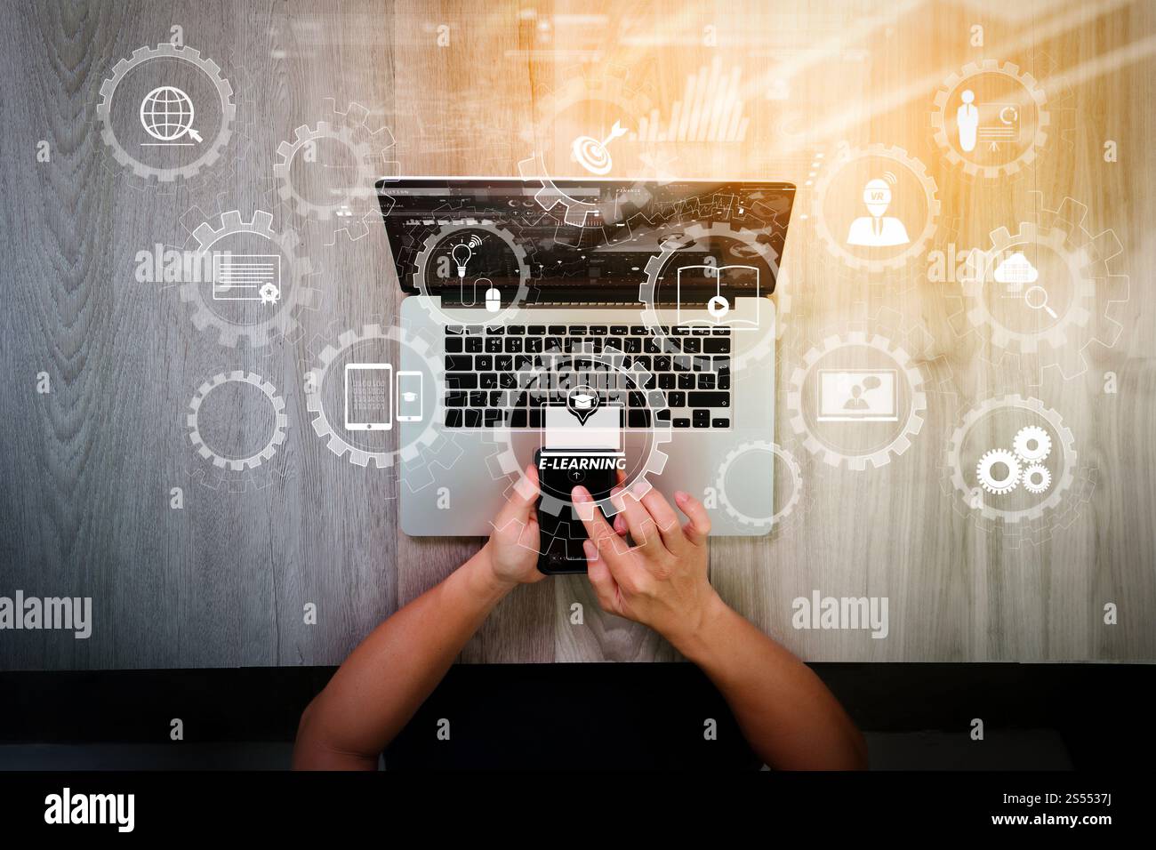 E-learning avec engrenages connectés diagramme connecté tableau de bord virtuel.vue de dessus de la main de concepteur travaillant avec un ordinateur portable et smartphone et Banque D'Images