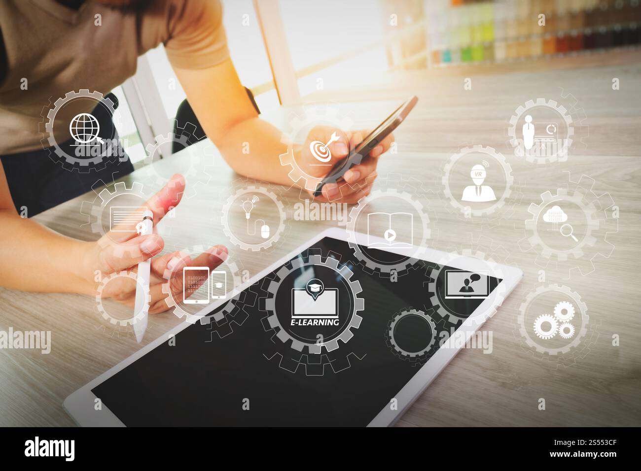 E-learning avec engrenages connectés diagramme connecté tableau de bord virtuel.homme d'affaires travaillant avec une tablette numérique et un téléphone intelligent sur bois Banque D'Images