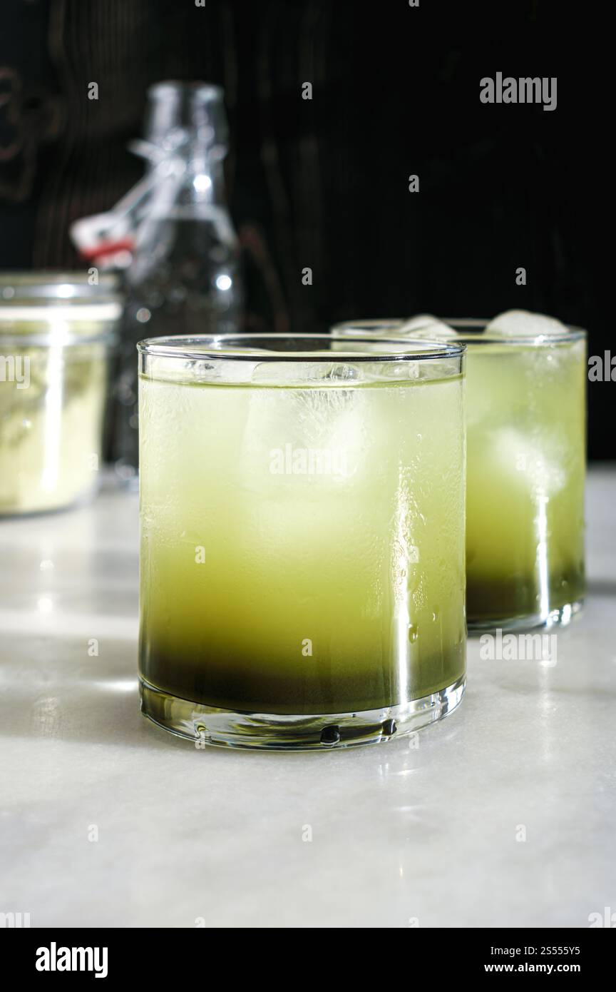Deux verres de Matca Soda avec glaçons : eau pétillante mélangée à du sirop simple matcha servi dans des verres de roches Banque D'Images