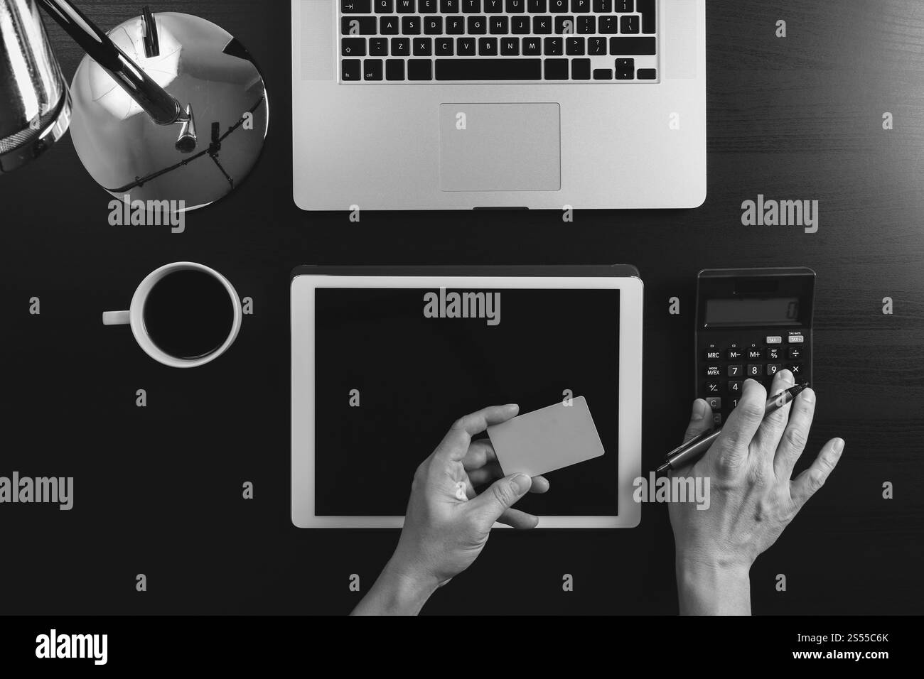 Concept d'achat sur Internet. Vue de dessus des mains travaillant avec la calculatrice et l'ordinateur portable et la carte de crédit et l'ordinateur tablette sur la table en bois foncé Banque D'Images