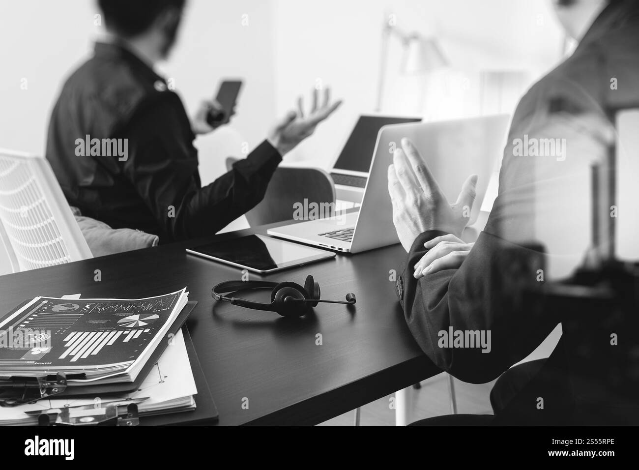 Co réunion de travail, deux hommes d'affaires utilisant le casque VoIP avec ordinateur latop sur le bureau dans le bureau moderne comme centre d'appels et bureau d'assistance de service à la clientèle Banque D'Images