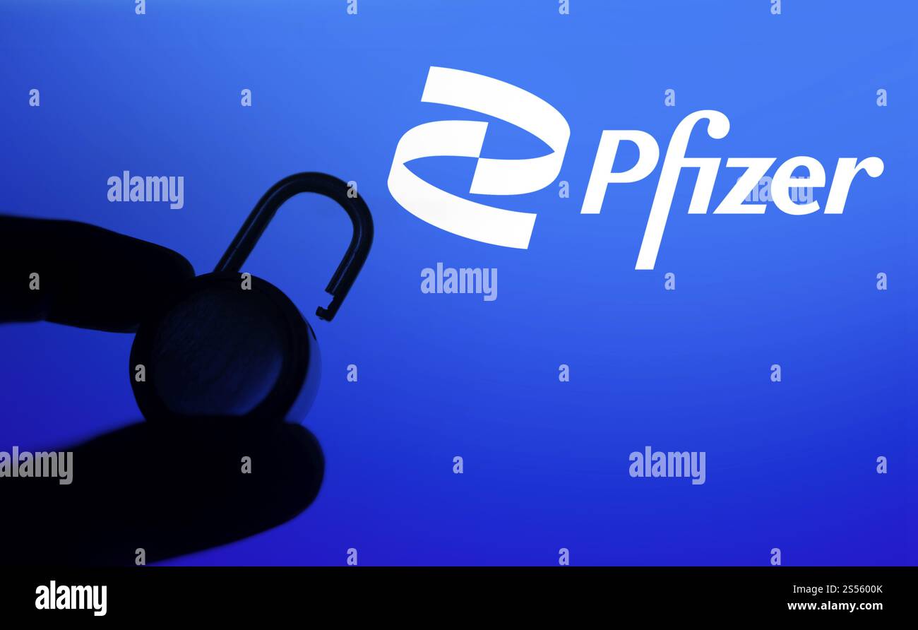 Une main tient un cadenas déverrouillé devant le logo pfizer. Pfizer Inc. est une multinationale américaine pharmaceutique et biotechnologique Banque D'Images