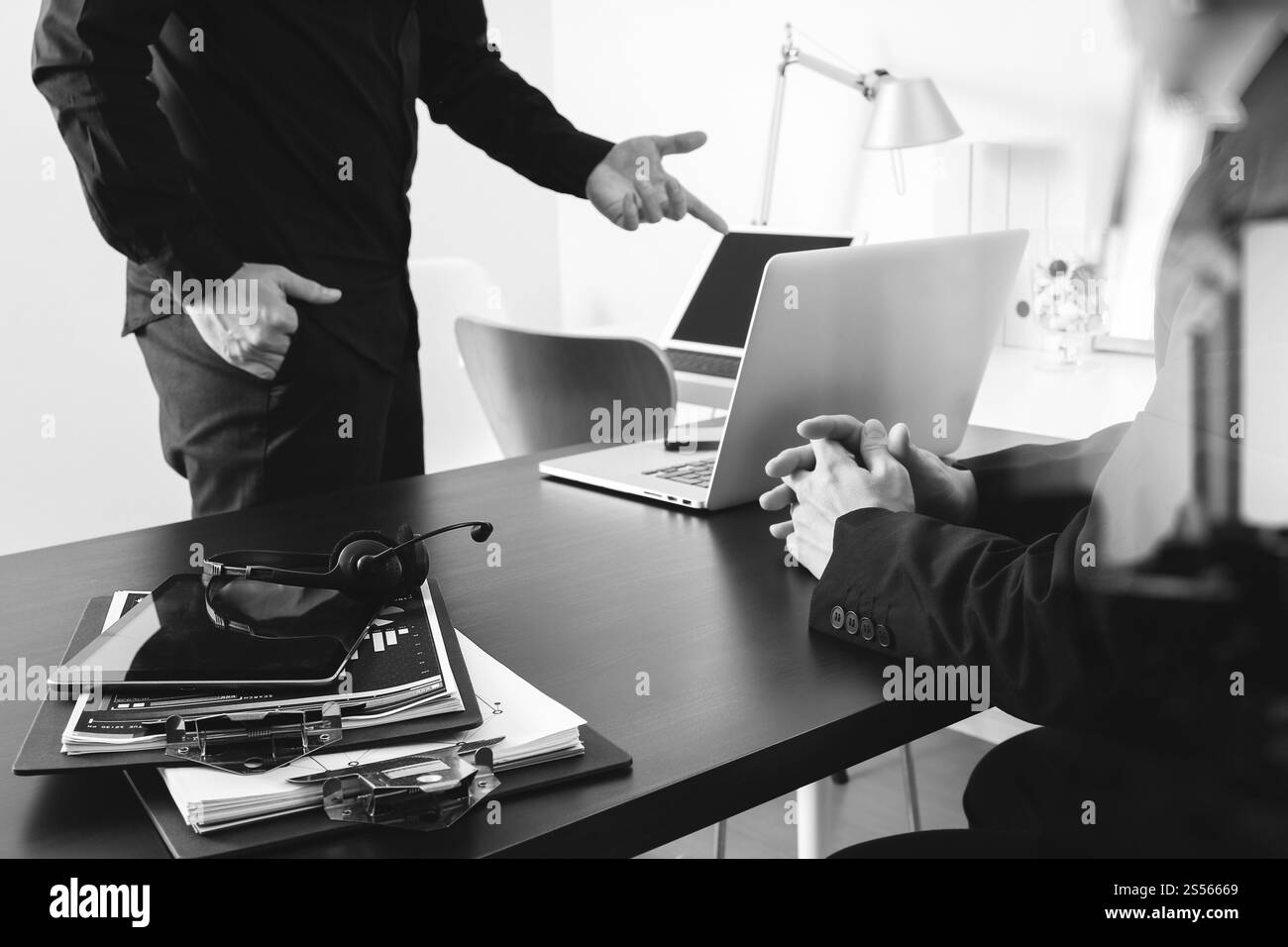 Co réunion de travail, deux hommes d'affaires utilisant le casque VoIP avec ordinateur latop sur le bureau dans le bureau moderne comme centre d'appels et bureau d'assistance de service à la clientèle Banque D'Images