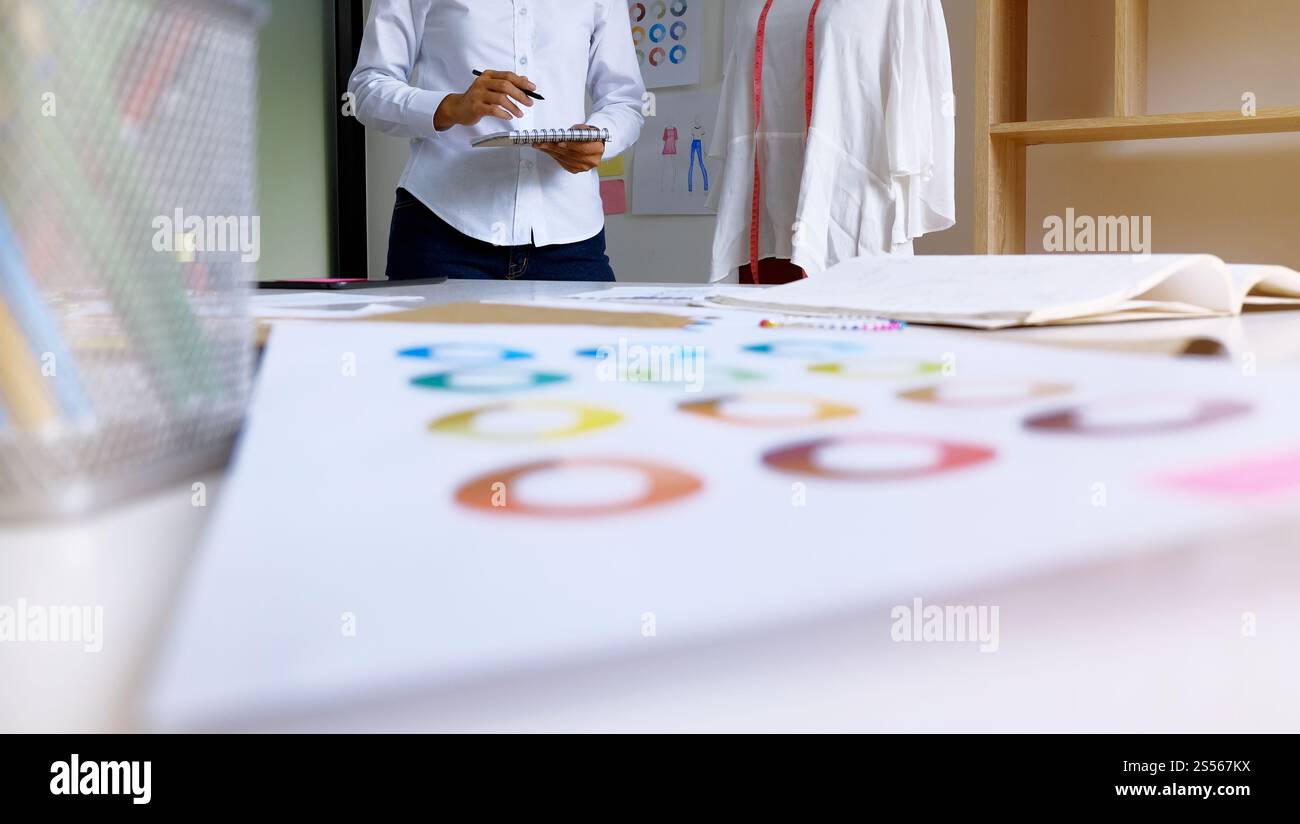 Élégant Fashion Designer travailler comme croquis de la nouvelle collection dans l'atelier. Concept de design créatif. Élégant dans la salle d'exposition Banque D'Images Élégant Fashion Designer travailler comme croquis de la nouvelle collection dans l'atelier. Concept de design créatif. Élégant dans la salle d'exposition Banque D'Images