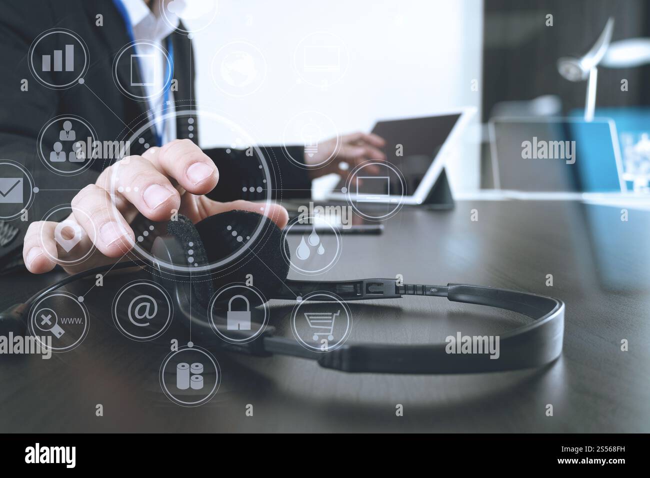 Homme utilisant un casque VoIP avec tablette numérique et ordinateur portable comme communication conceptuelle, support informatique, centre d'appels et service client avec Banque D'Images