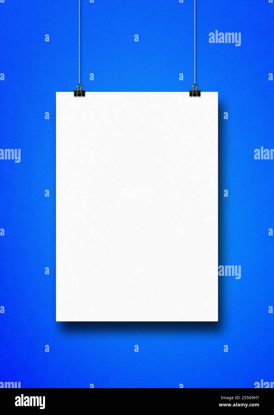 Affiche blanche accrochée sur un mur bleu avec des clips. Modèle de maquette vierge. Affiche blanche accrochée sur un mur bleu avec des clips Banque D'Images