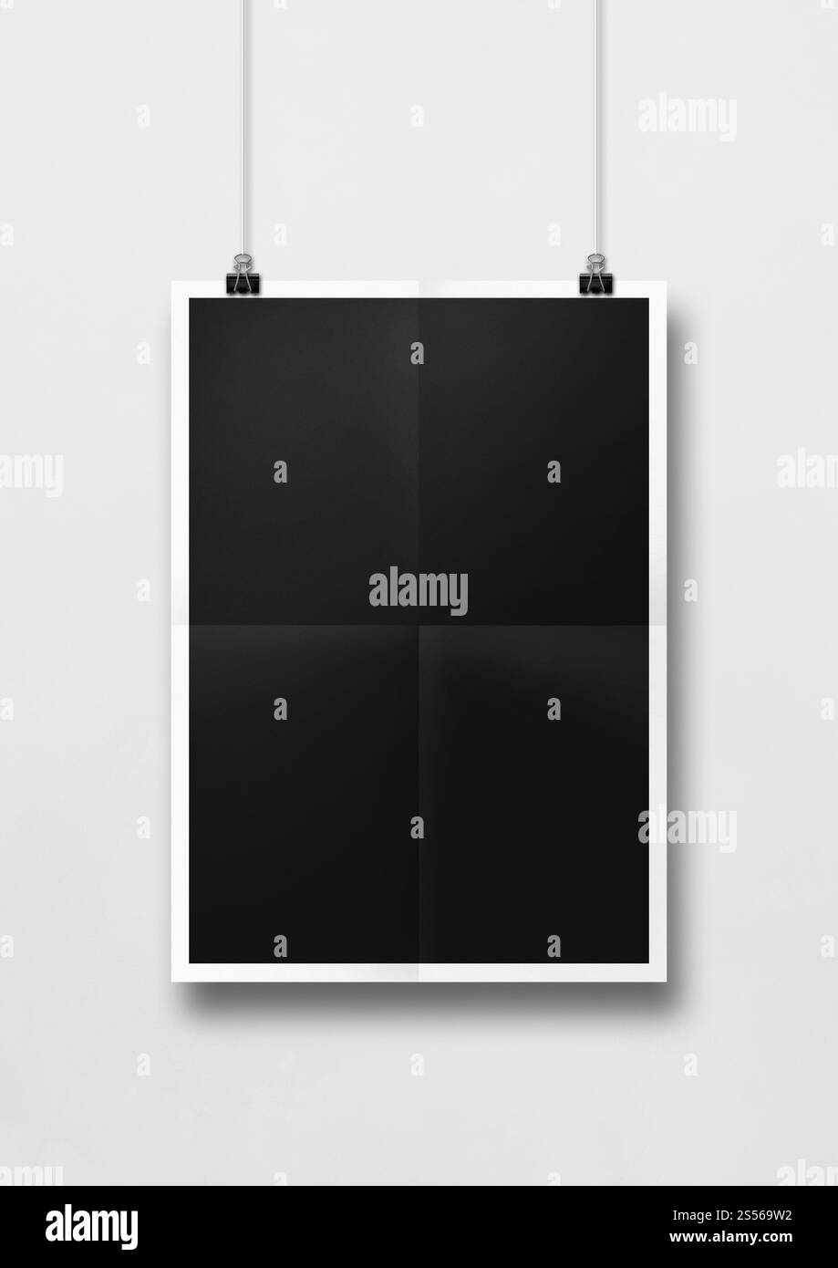 Affiche pliée noire accrochée sur un mur blanc avec des clips. Modèle de maquette vierge. Affiche pliée noire accrochée sur un mur blanc avec des clips Banque D'Images