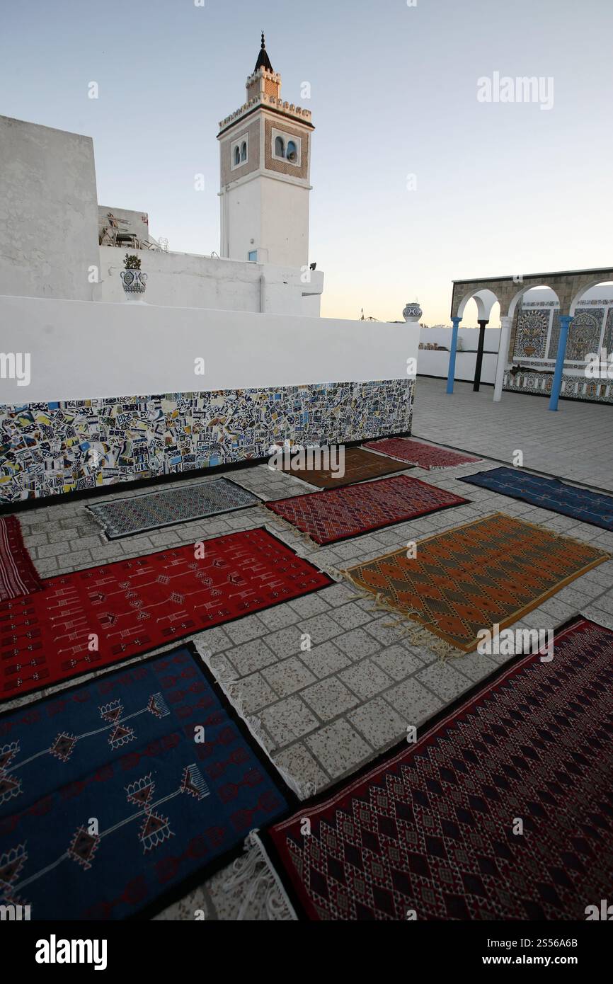 Un magasin de tapis et de production devant une ancienne mosquée dans la médina de la vieille ville de Tunis au nord de la Tunisie en Afrique du Nord, Tunisie, Sidi Bou Banque D'Images