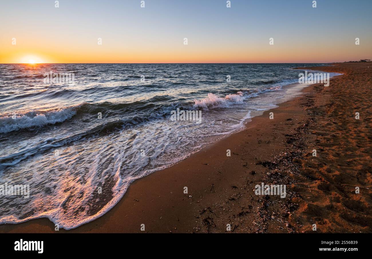 Lever de soleil coloré sur la plage de la mer avec ciel et soleil clairs le matin au-dessus de l'horizon Banque D'Images
