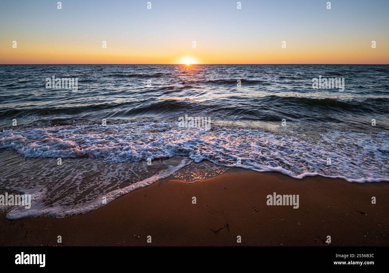 Lever de soleil coloré sur la plage de la mer avec ciel et soleil clairs le matin au-dessus de l'horizon Banque D'Images