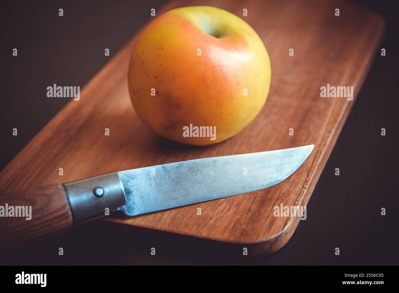Pomme fraîche bio et couteau de poche sur une planche à découper en bois. Pomme et couteau de poche sur une planche à découper en bois Banque D'Images