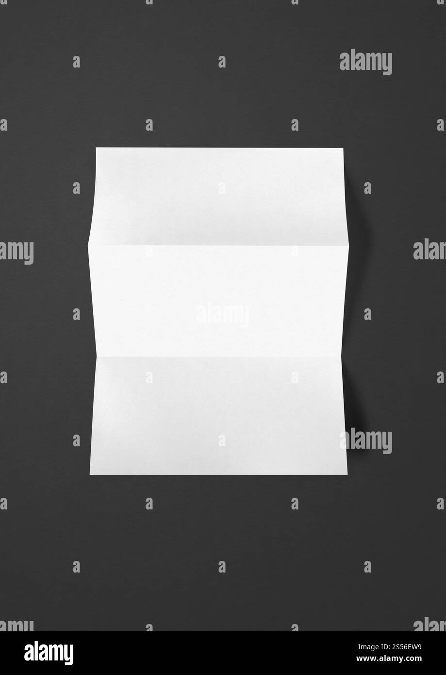 Modèle de maquette de feuille de papier A4 blanc plié vierge isolé sur fond noir. Modèle de maquette de feuille de papier A4 blanc plié vierge sur fond noir Banque D'Images