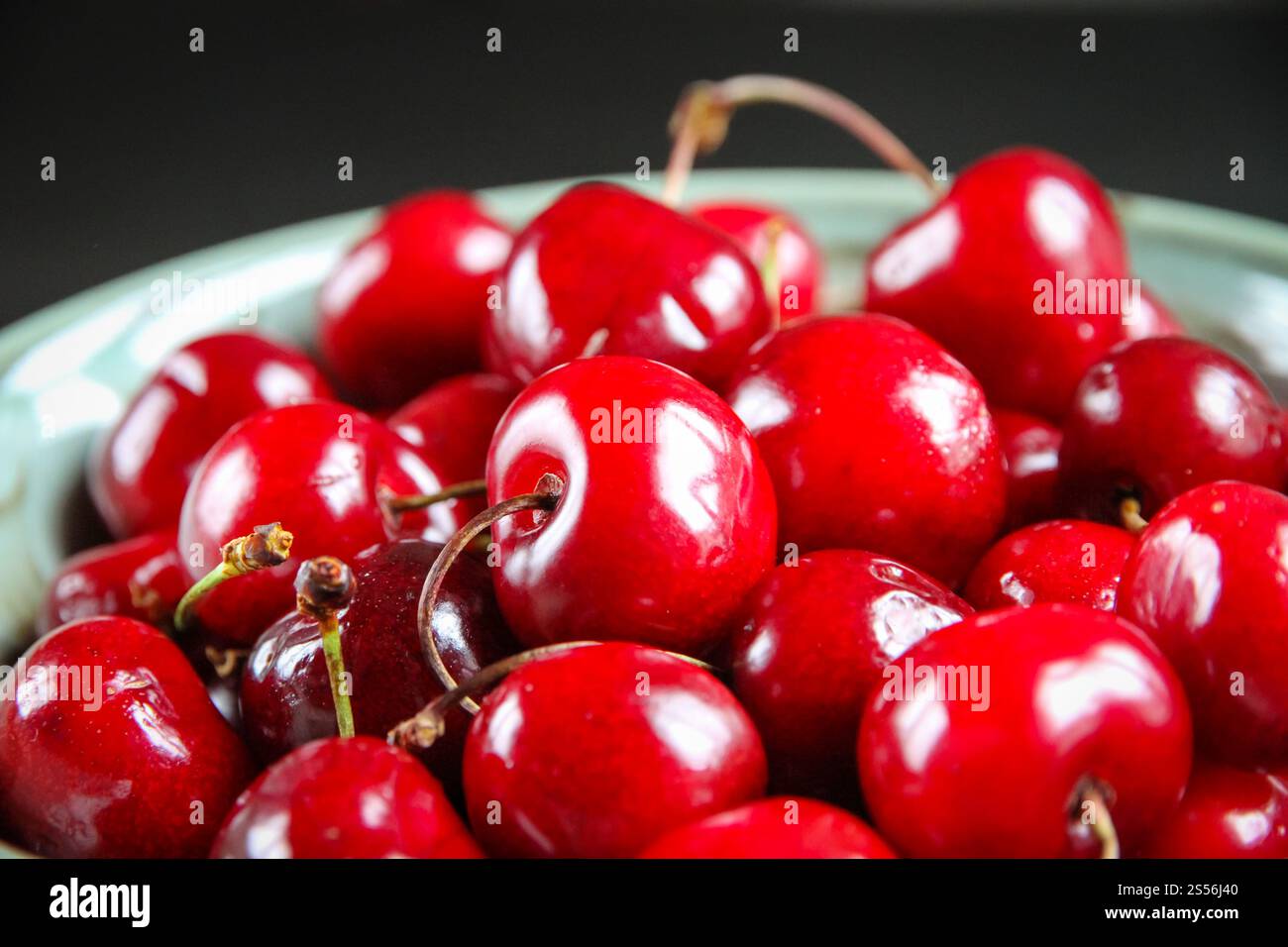 Bouquet de cerises fraîches biologiques dans un bol. Cerises fraîches dans un bol Banque D'Images
