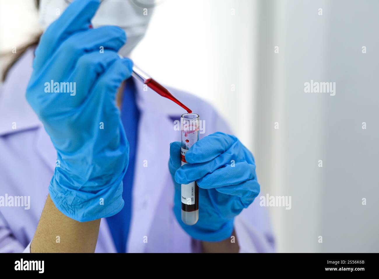 Scientifique tenant un tube de prélèvement sanguin infecté par le coronavirus covid-19. Analyse ADN du sang en laboratoire avec des tubes de prélèvement de sang et Banque D'Images