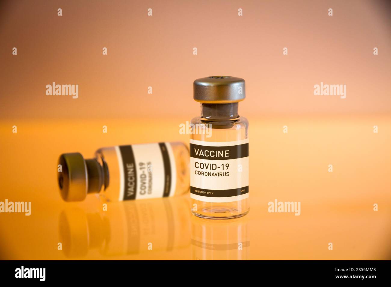 Flacons de vaccin COVID-19 sur fond jaune de laboratoire. Flacons de vaccin COVID-19 sur fond jaune Banque D'Images