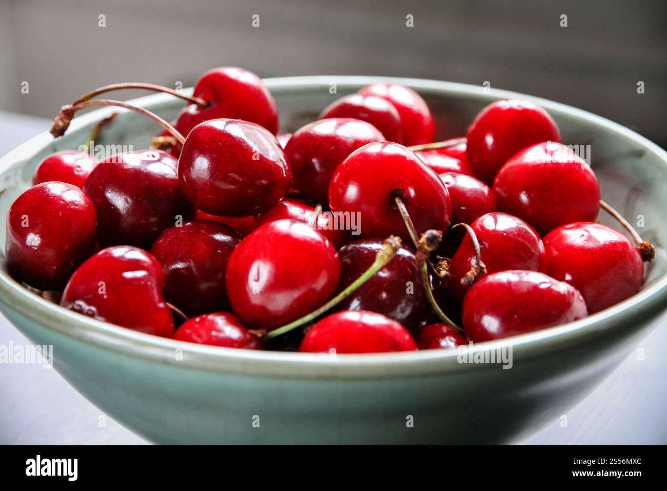 Bouquet de cerises fraîches biologiques dans un bol. Cerises fraîches dans un bol Banque D'Images