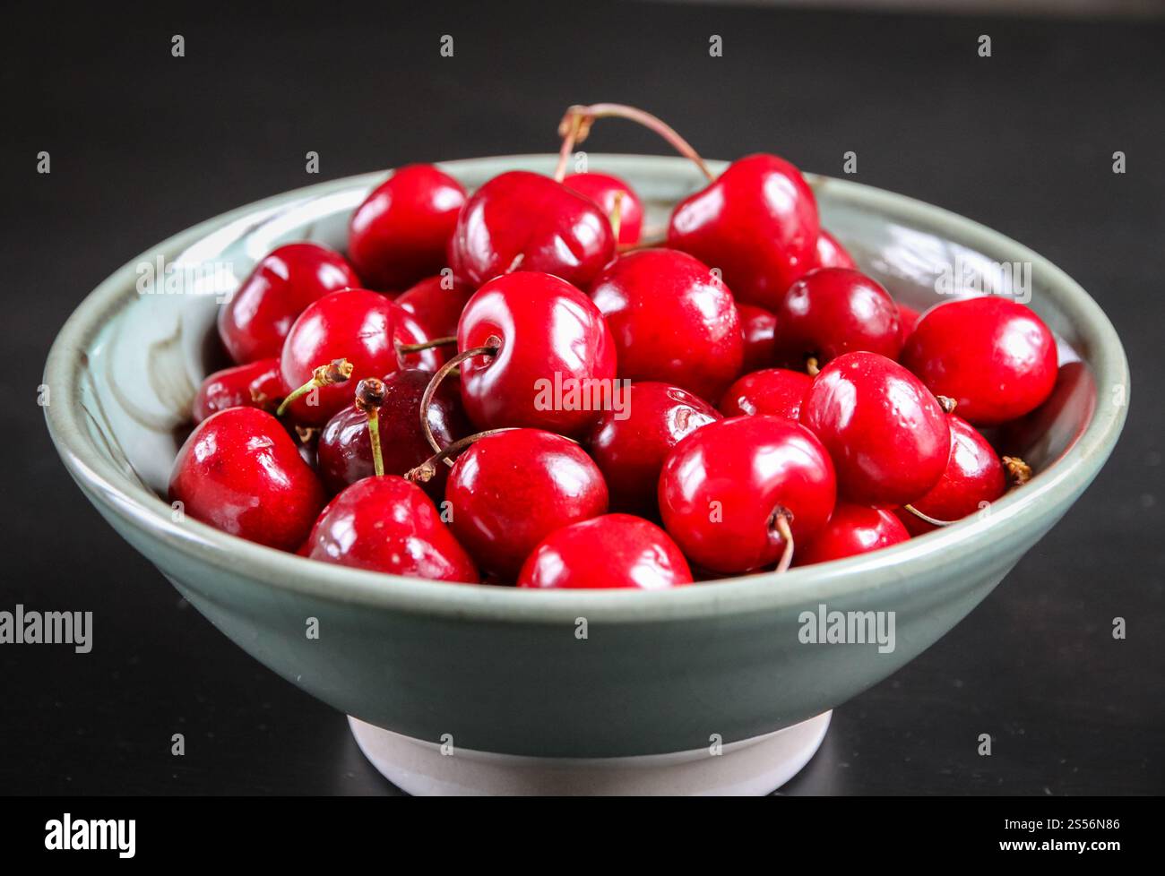 Bouquet de cerises fraîches biologiques dans un bol. Cerises fraîches dans un bol Banque D'Images