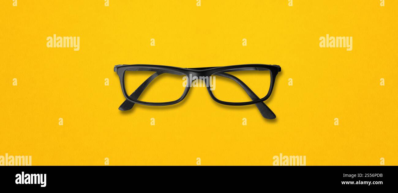 Lunettes noires isolées sur une bannière de fond jaune. Lunettes noires isolées sur bannière jaune Banque D'Images