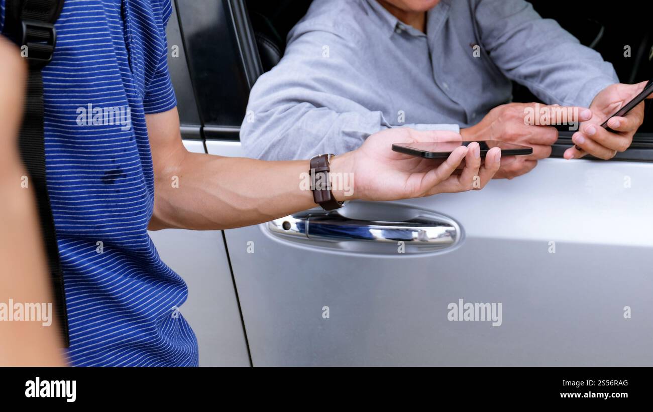 Taxi Transfer Service chauffeur parlant avec le passager et tenant le téléphone portable en main pour attendre Taxi Banque D'Images