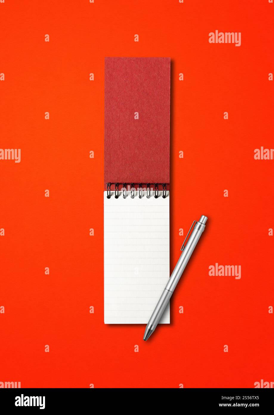 Cahier à spirale ouvert vierge et maquette de stylo isolé sur rouge. Cahier à spirale ouvert vierge et stylo isolé sur rouge Banque D'Images