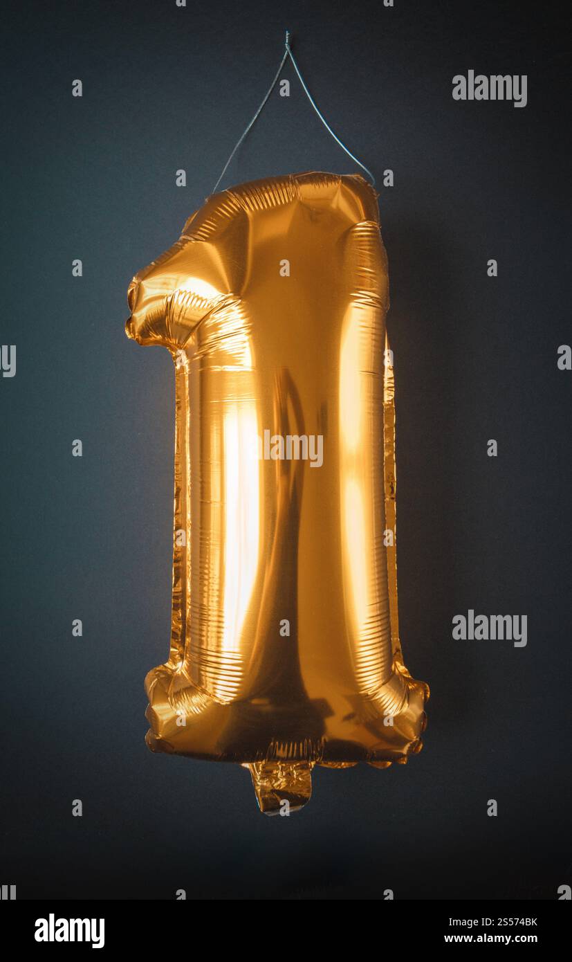 Feuille d'or ballon numéro un isolé sur fond noir. Feuille d'or ballon numéro un isolé sur noir Banque D'Images