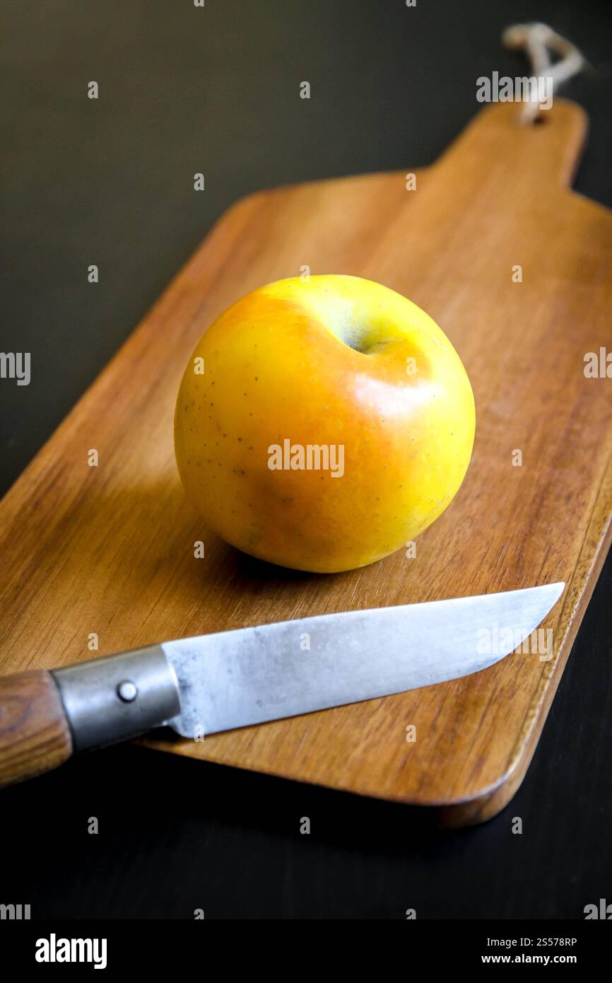 Pomme fraîche bio et couteau de poche sur une planche à découper en bois. Pomme et couteau de poche sur une planche à découper en bois Banque D'Images