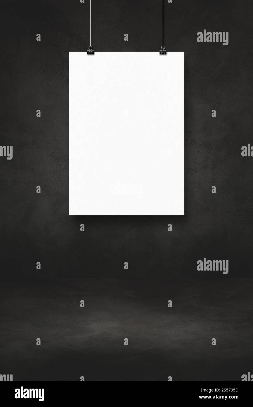 Affiche blanche accrochée sur un mur noir avec des clips. Modèle de maquette vierge. Affiche blanche accrochée sur un mur noir avec des clips Banque D'Images