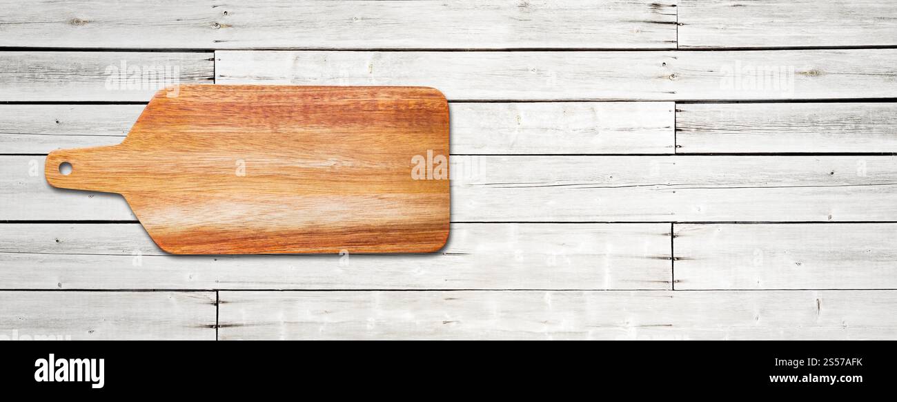 Planche à découper en bois isolé sur fond de bois blanc. Bannière panoramique horizontale. Planche à découper en bois isolé sur fond de bois blanc. Banque D'Images