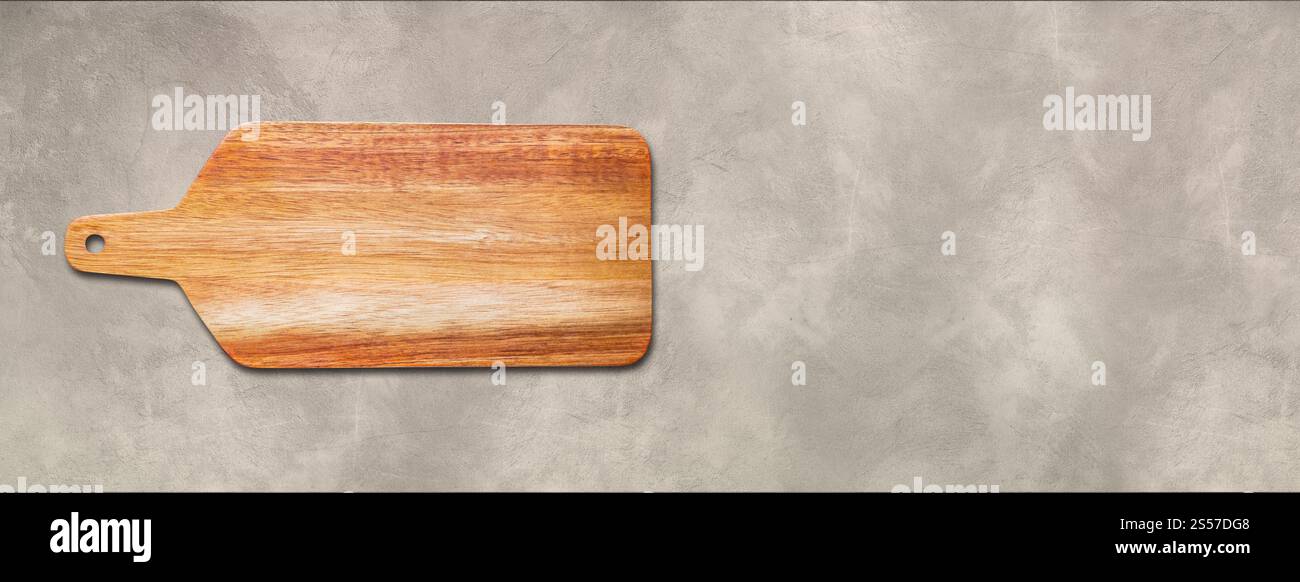 Planche à découper en bois isolé sur fond de béton. Bannière panoramique horizontale. Planche à découper en bois isolé sur fond de béton. Horizontal Banque D'Images
