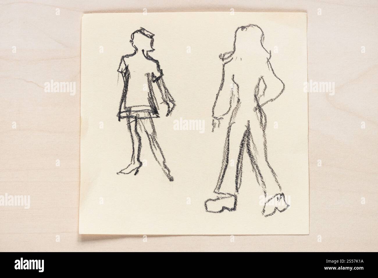 Croquis de la silhouette à la mode des femmes des années 60 et 70 du XX siècle dessiné à la main avec un crayon noir graphite sur papier à notes marron clair Banque D'Images Croquis de la silhouette à la mode des femmes des années 60 et 70 du XX siècle dessiné à la main avec un crayon noir graphite sur papier à notes marron clair Banque D'Images