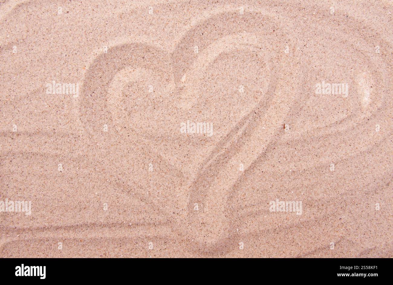 dessin de coeur sur fond de sable marin ou texture. coeur dessinant sur le sable marin Banque D'Images
