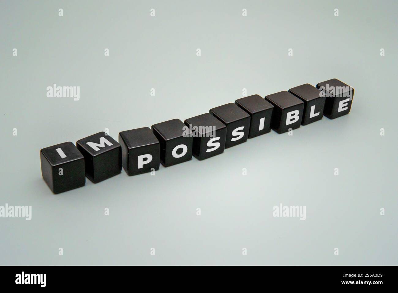 Blocs avec les lettres 'IMPOSSIBLE' réarrangées pour écrire 'POSSIBLE'. Motivation, surmonter les défis et atteindre le concept des objectifs. Banque D'Images