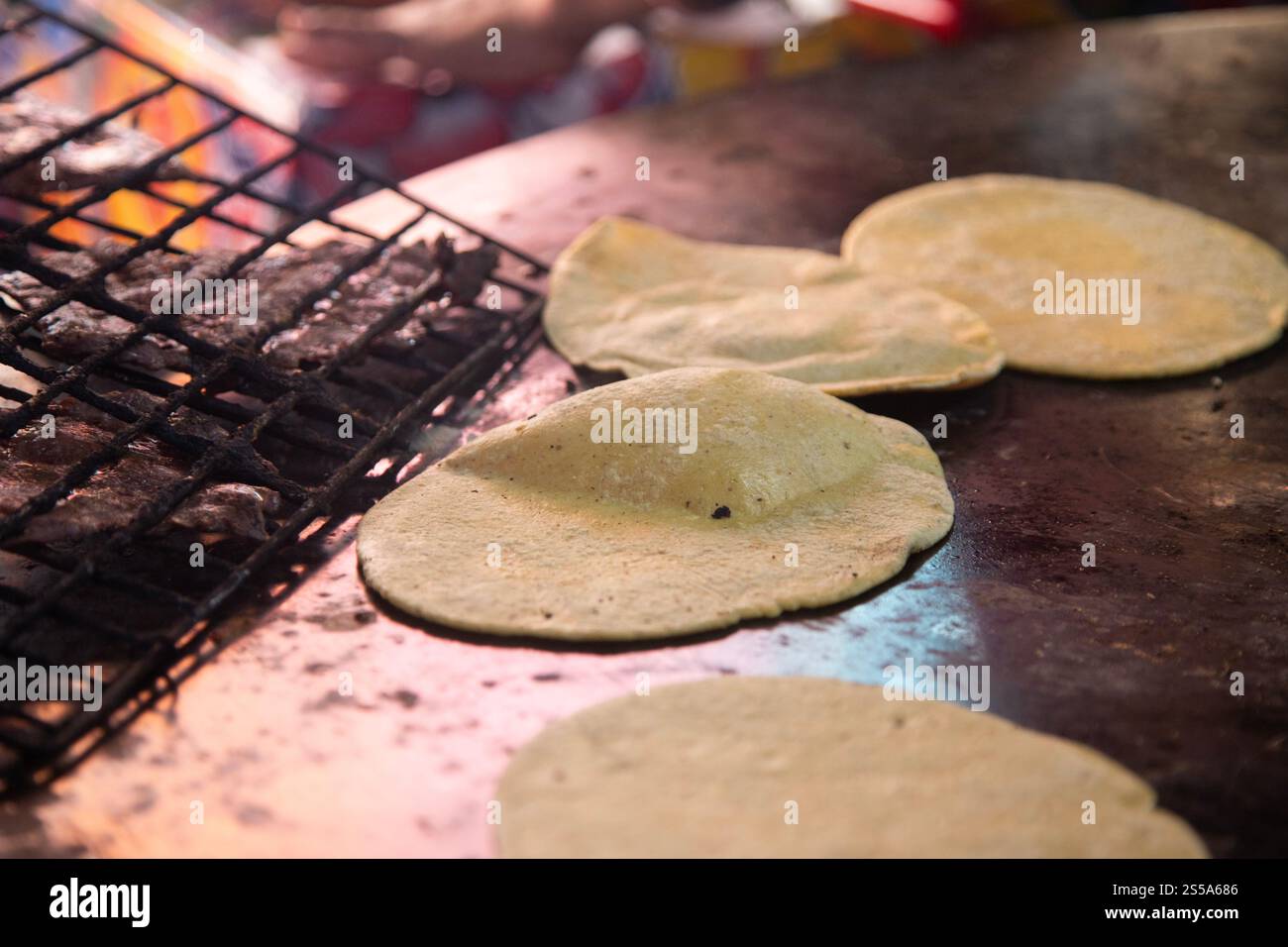 Cuisson de memelas au marché d'Oaxaca Central de Abastos avec fromage local, porc séché, œufs et sauce piquante. Banque D'Images