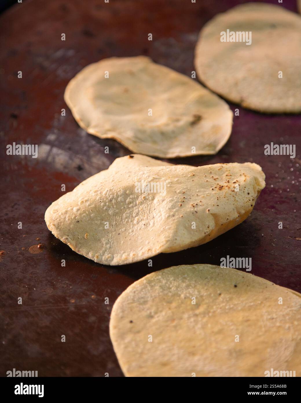 Cuisson de memelas au marché d'Oaxaca Central de Abastos avec fromage local, porc séché, œufs et sauce piquante. Banque D'Images