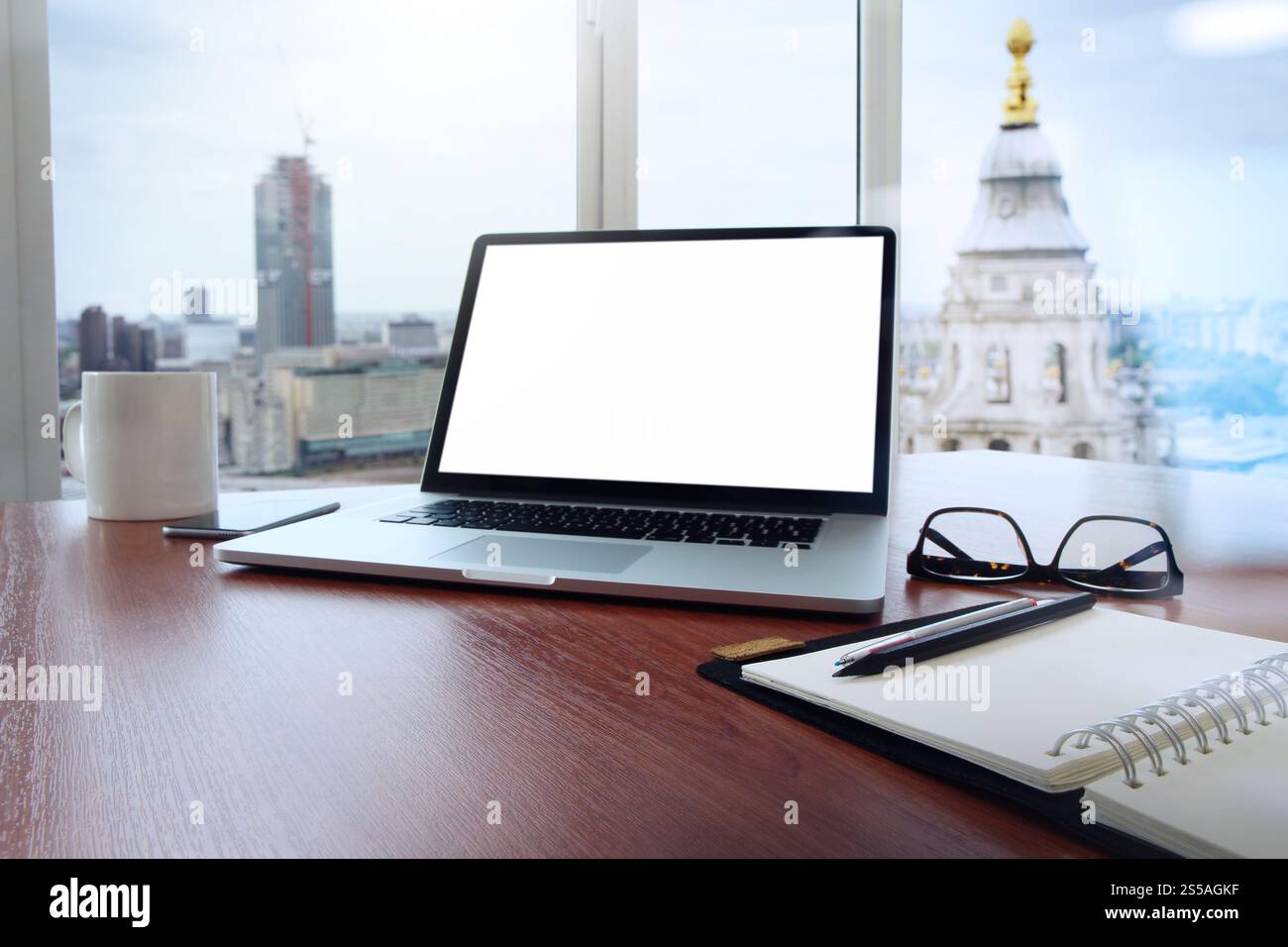 Travail de bureau avec ordinateur portable et téléphone intelligent sur table en bois et London city arrière-plan flou Banque D'Images