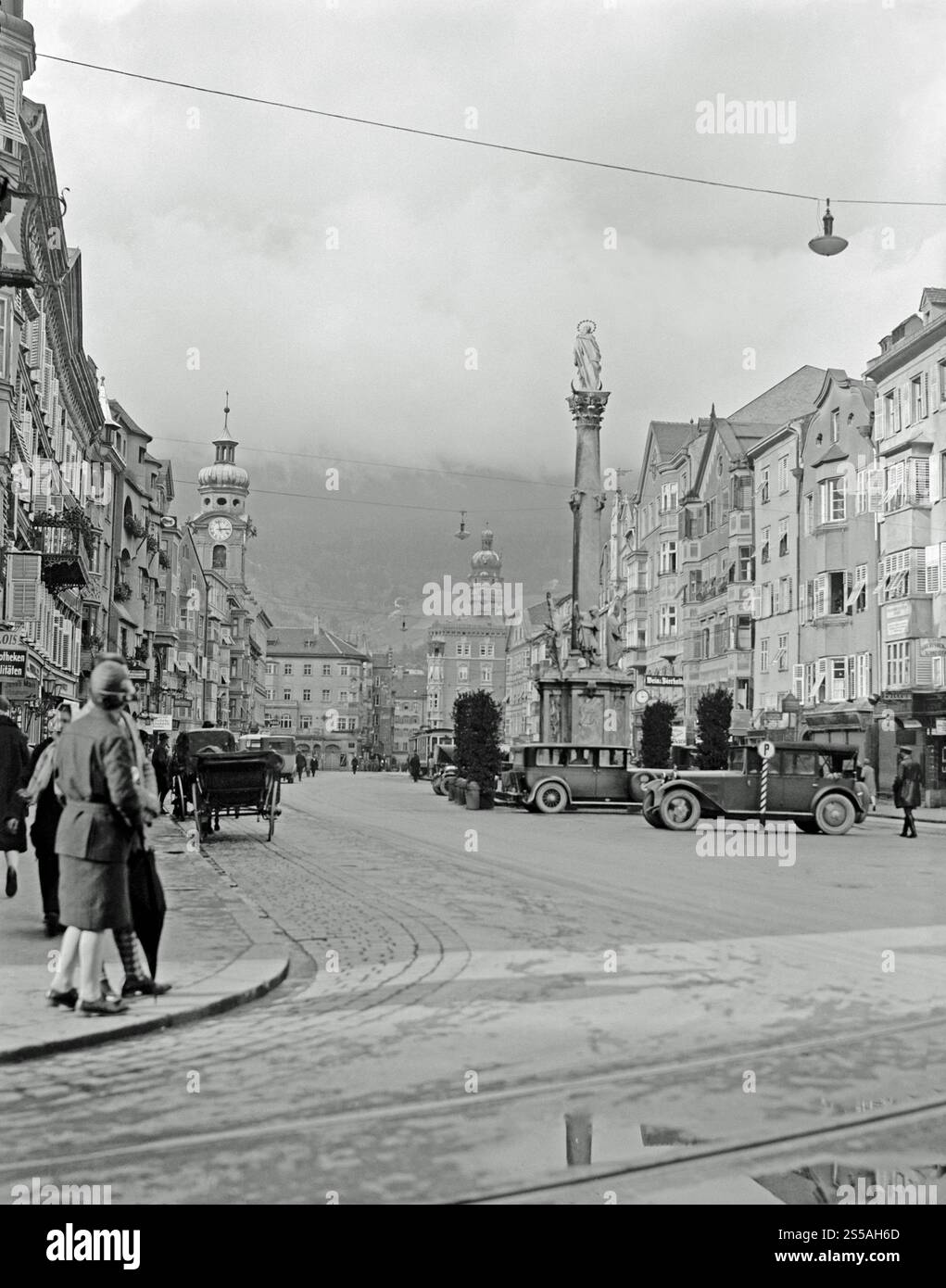 Une vue vers le nord le long de Maria Theresien Strasse, Innsbruck, Tyrol, Autriche vers 1930. Derrière les voitures garées dans le centre-ville se trouve la colonne d'Anne (Annasäule), commémorant lorsque les dernières troupes bavaroises ont été chassées du Tyrol le 26 juillet 1703, lors de la guerre de succession d'Espagne. La colonne a été réalisée en marbre rouge de Kramsach en 1706 par le sculpteur Cristoforo Benedetti. Innsbruck est la capitale du Tyrol et la cinquième plus grande ville d'Autriche. Banque D'Images Une vue vers le nord le long de Maria Theresien Strasse, Innsbruck, Tyrol, Autriche vers 1930. Derrière les voitures garées dans le centre-ville se trouve la colonne d'Anne (Annasäule), commémorant lorsque les dernières troupes bavaroises ont été chassées du Tyrol le 26 juillet 1703, lors de la guerre de succession d'Espagne. La colonne a été réalisée en marbre rouge de Kramsach en 1706 par le sculpteur Cristoforo Benedetti. Innsbruck est la capitale du Tyrol et la cinquième plus grande ville d'Autriche. Banque D'Images
