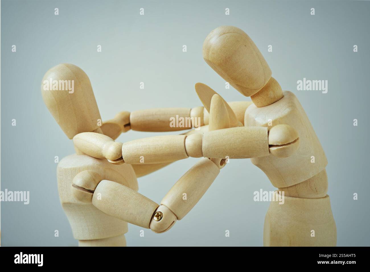 Mannequin en bois violent attaquant un faible - concept de violence, d'intimidation et de tergiversation Banque D'Images