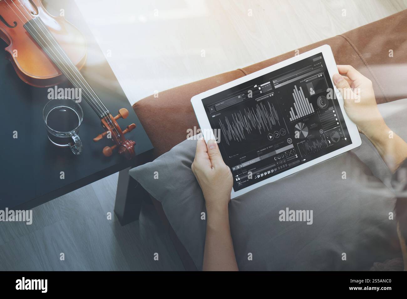 Hipster part composer la musique avec tablette numérique compter et sitting on sofa at home studio Banque D'Images