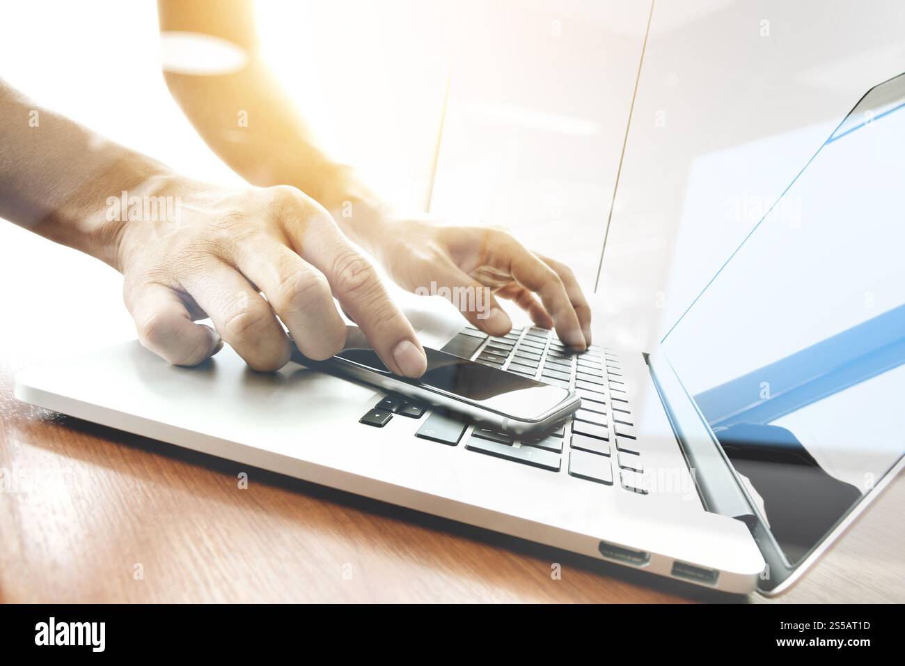 Main designer travaillant et smart phone et l'ordinateur portable sur un bureau en bois Banque D'Images