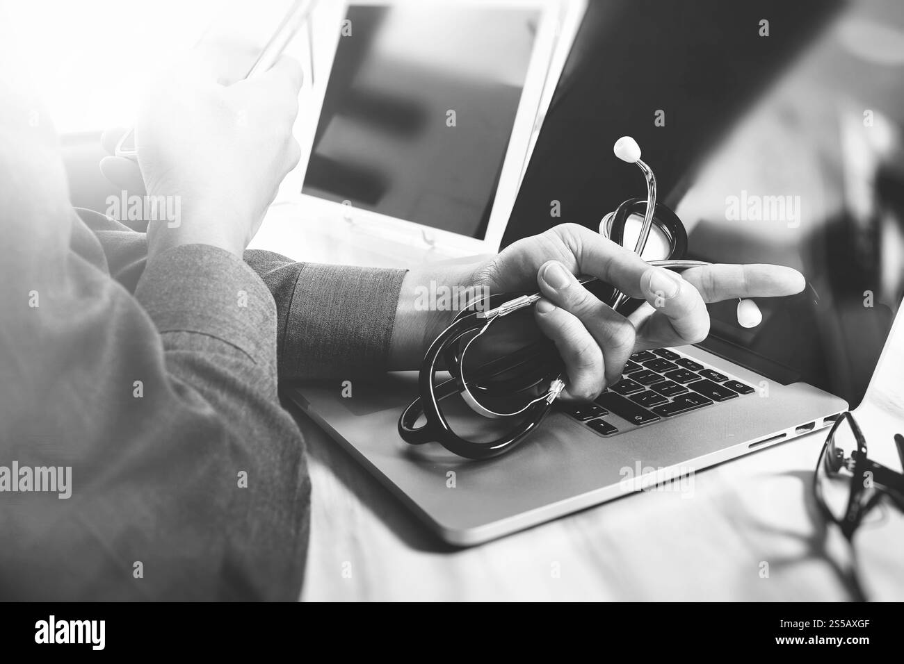 Concept de technologie médicale. Médecin part travailler avec tablette numérique moderne et ordinateur portable avec interface graphique médical, noir blanc Banque D'Images